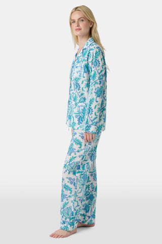 The Amanda Loungewear pajama set features white cotton fabric adorned with blue and turquoise floral and botanical patterns, adding a charming, intricate touch to women’s sleepwear.