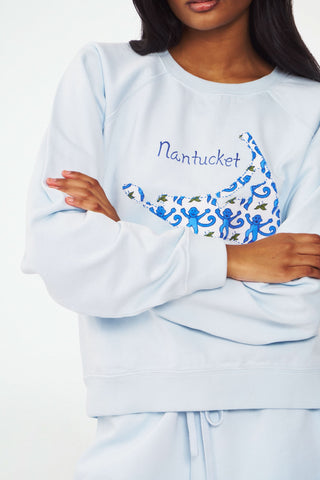 A woman models the Roller Rabbit ACK Applique Crewneck and matching shorts with a floral Nantucket outline and "Nantucket" text, standing against a plain white background.