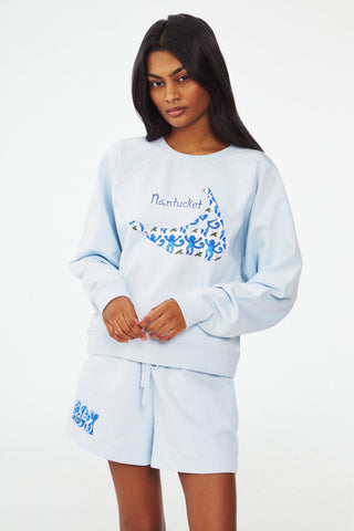 A person wears the Roller Rabbit ACK Applique Shortie, paired with a light blue whale-decorated Nantucket sweatshirt. The shortie features patchwork "ACK" letters near the hem.