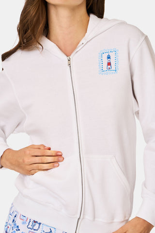 A person wearing the Roller Rabbit ACK Zip Up hoodie, featuring a blue and red nautical design on the back, paired with patterned shorts and standing with their back to the camera and hood up.
