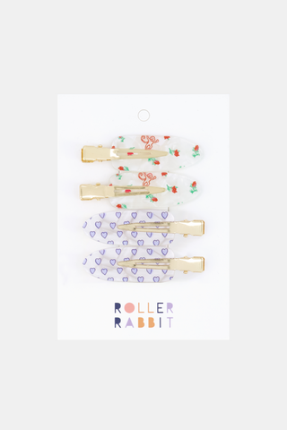 Add a playful touch to your GRWM routine with the Mini Monkey Blossom Makeup Clips from Roller Rabbit. This set includes four mix-and-match hair clips—two orange clips featuring whimsical rabbit faces and tiny red blossoms, plus two blue heart-shaped clips—all displayed on a white card adorned with ROLLER RABBIT printed in pastel colors at the bottom.