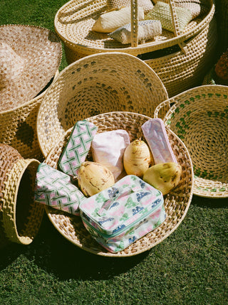 Woven baskets with decorative items on a grassy surface